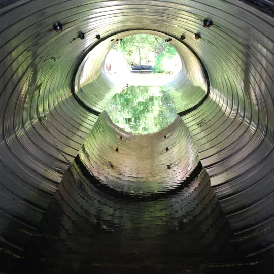 A culvert made from Smooth Cor corrugated metal pipe.