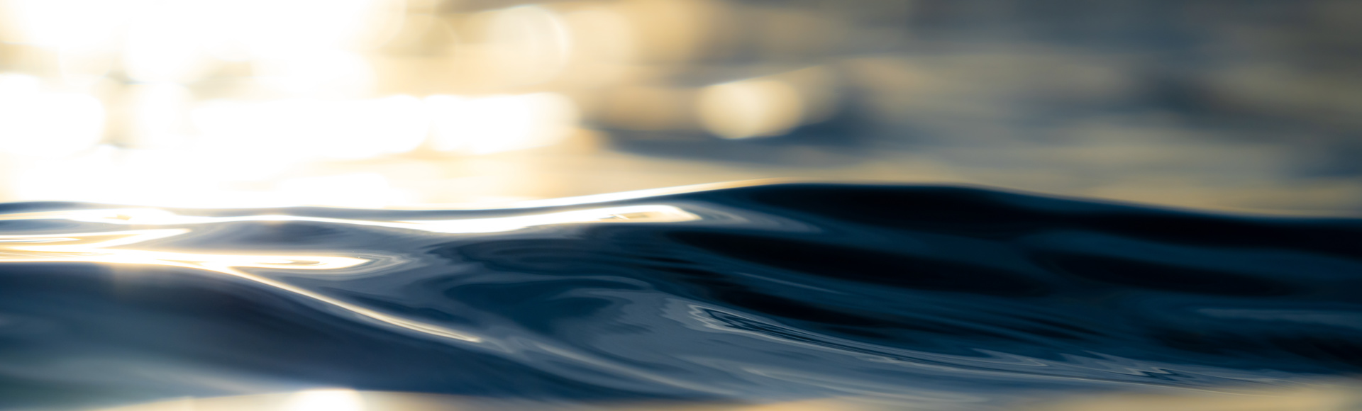 Close-up of gentle ocean waves with sunlight reflecting on the water's surface.
