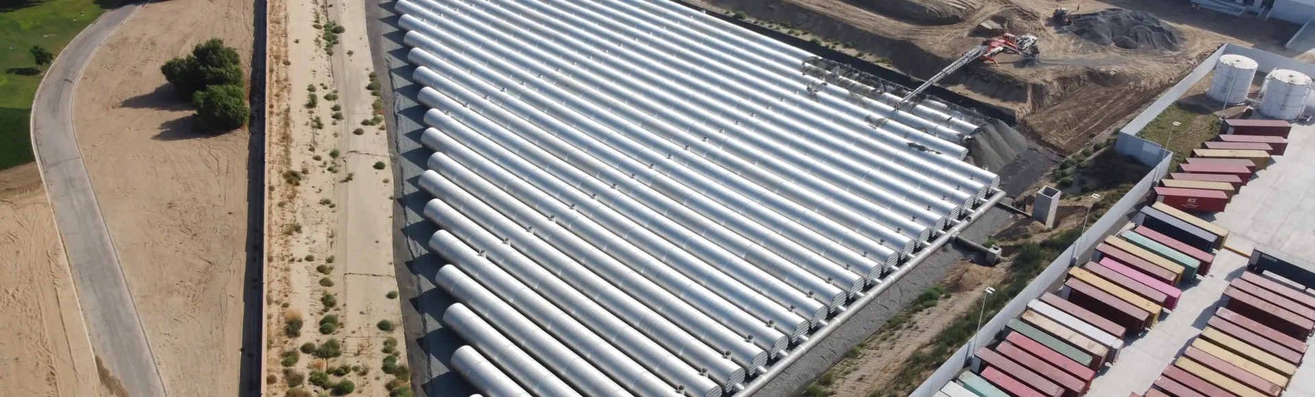 An aerial view of a large corrugated metal pipe stormwater underground detention system.