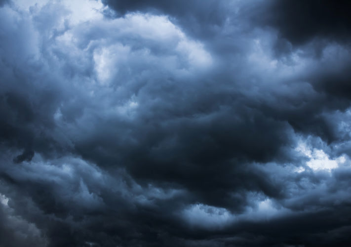 Dark, dense storm clouds cover the sky, creating a dramatic and moody atmosphere.