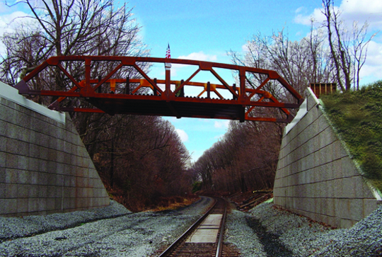 A truss bridge over a rail line. 