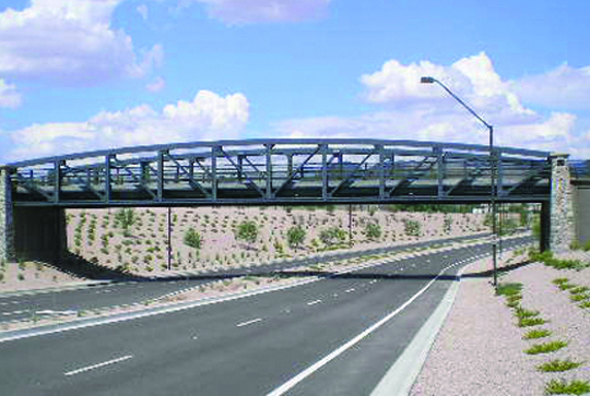 A truss bridge over a highway. 