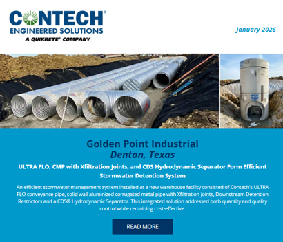 A stormwater system with large metal pipes and a concrete structure installed at an industrial site under construction.