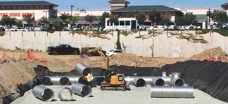 A corrugated metal pipe stormwater detention system is under construction.